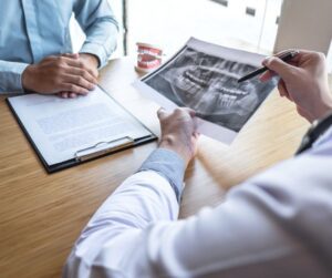 Dentist discussing dental X-ray with patient.