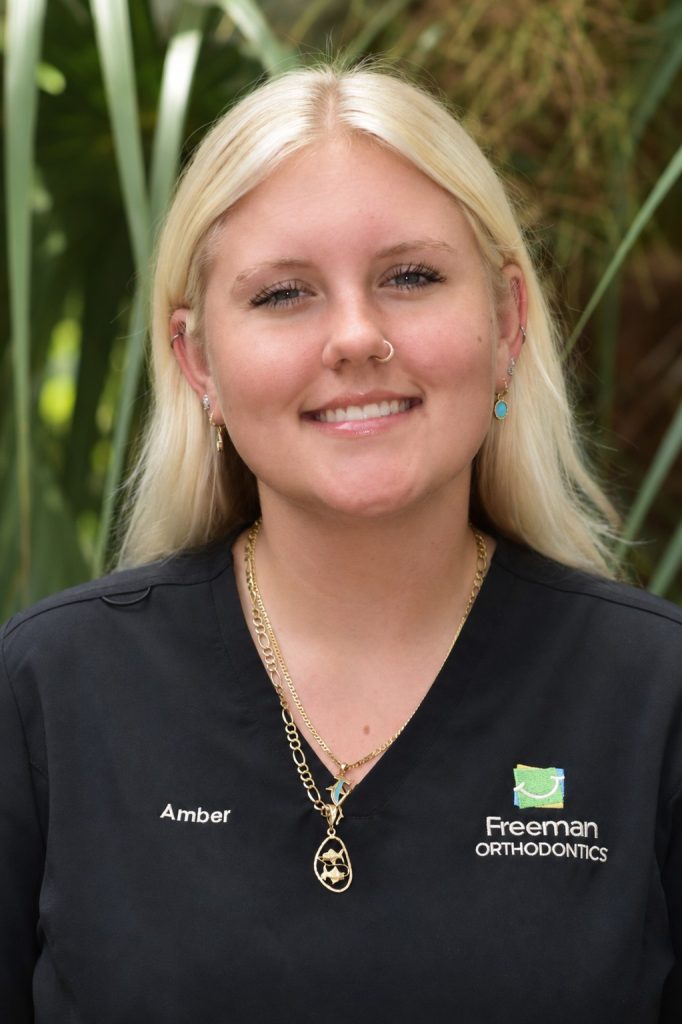 Smiling blonde woman in orthodontics uniform