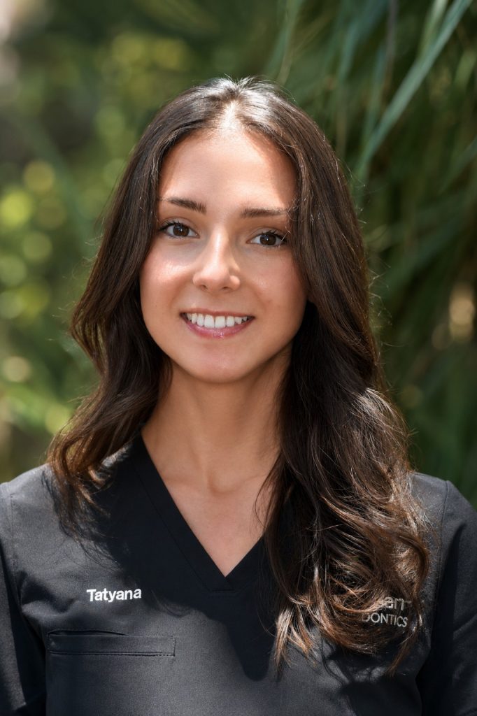 Smiling woman in black medical scrubs